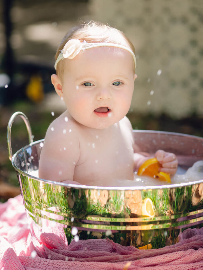 Outdoor Fruit Bath with an older newborn