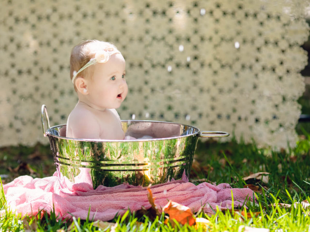 Outdoor Fruit Bath with an older newborn